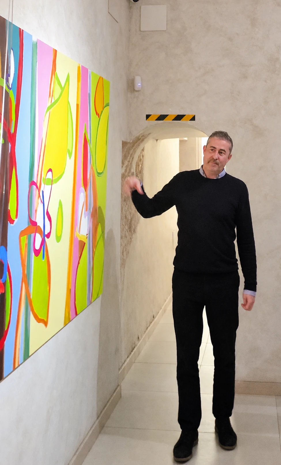 Tomás Santos Alcalá explica una de sus pinturas durante la visita guiada a su exposición en el Museo Cromática de Toledo.